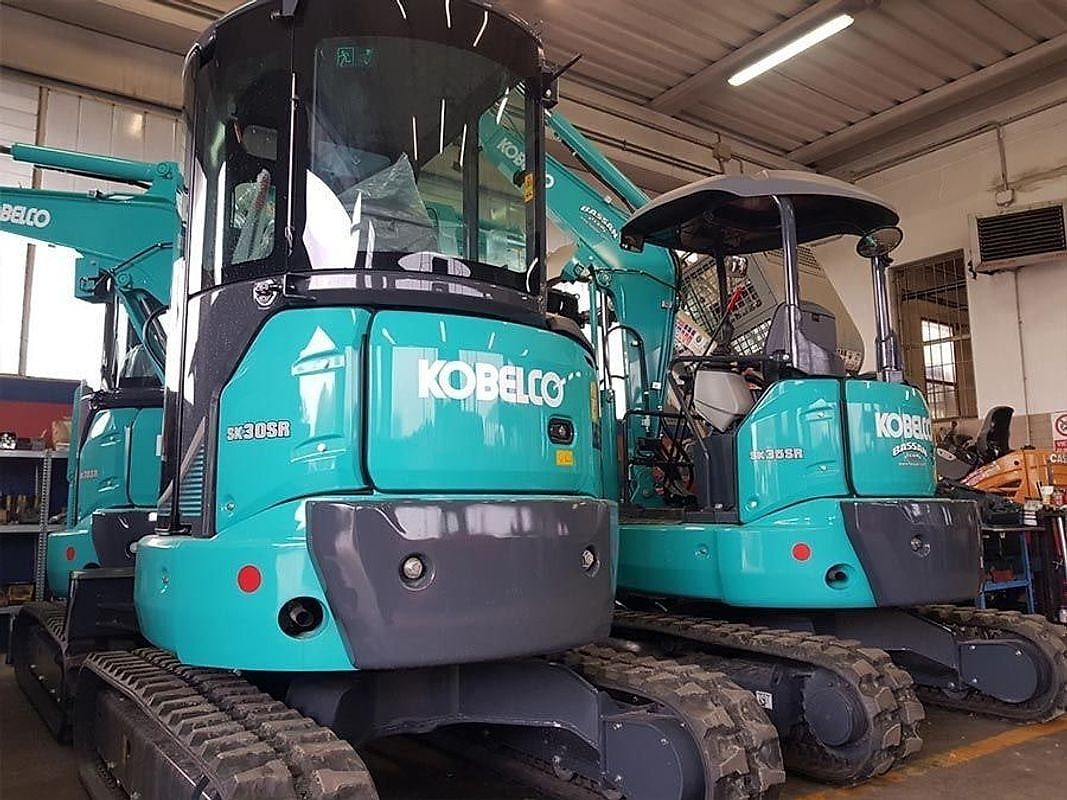 Due mini escavatori Kobelco della flotta a noleggio dentro il capannone.