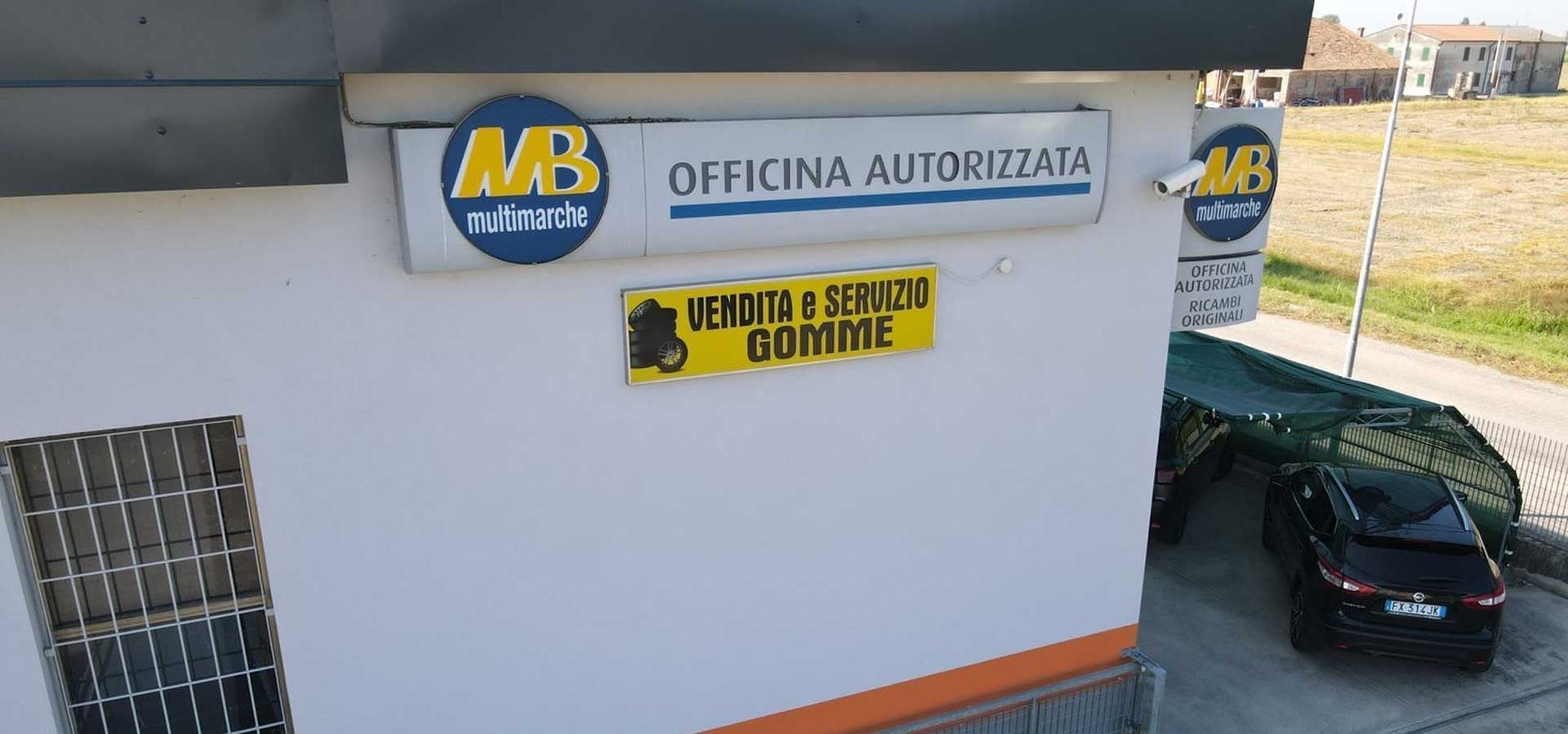 L'insegna «Officina autorizzata multimarche» e «Vendita e servizio gomme» dentro l'officina.