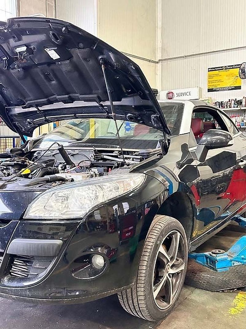 Un'automobile con il cofano aperto durante la riparazione della parte anteriore.
