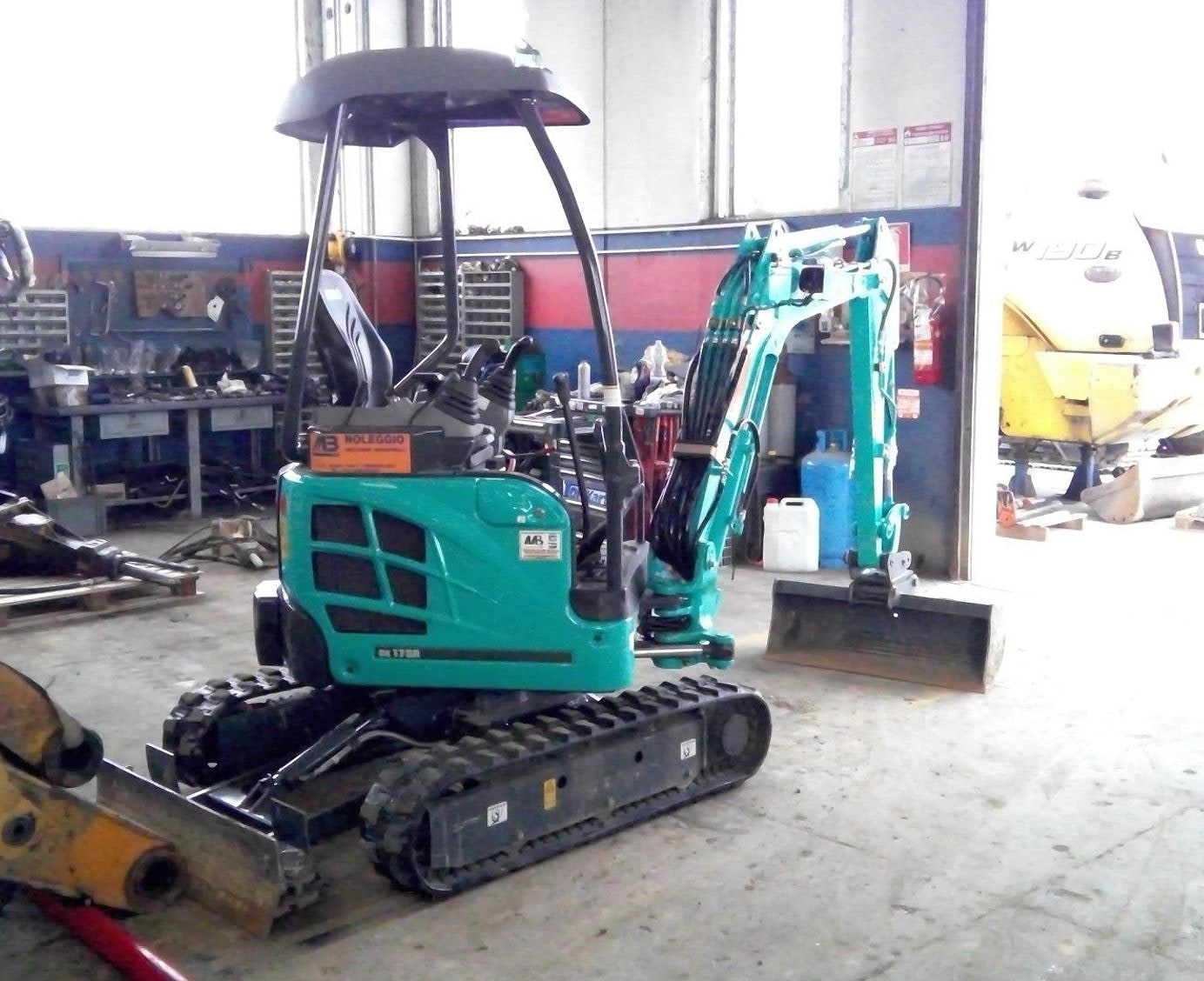 L'interno dell'officina con i mini escavatori e le macchine operatrici in lavorazione.