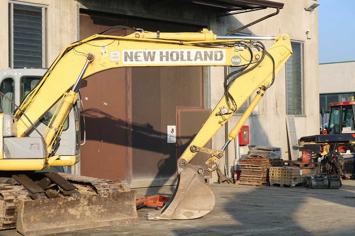 Un escavatore New Holland della flotta a noleggio davanti al capannone.