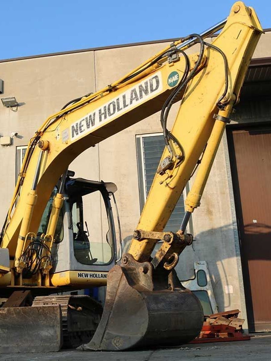 Un escavatore New Holland al lavoro sul piazzale dell'officina.